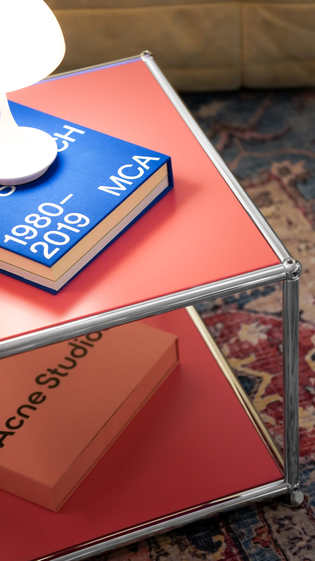 Ein rosanes Möbelstück von konektra mit einem Buch und einer Lampe darauf